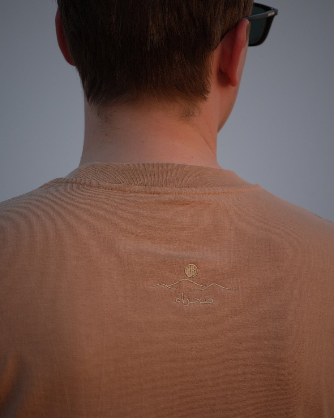 The Empty Quarter tee, back neck close — the printed collar label below the collar seam