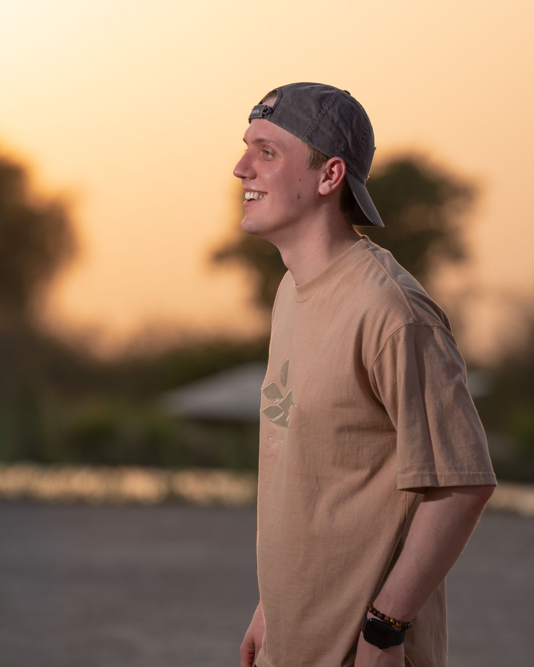 The Empty Quarter tee at golden hour, three-quarter — the tonal embroidery catching the light. Male model wears M in the Oversized fit.