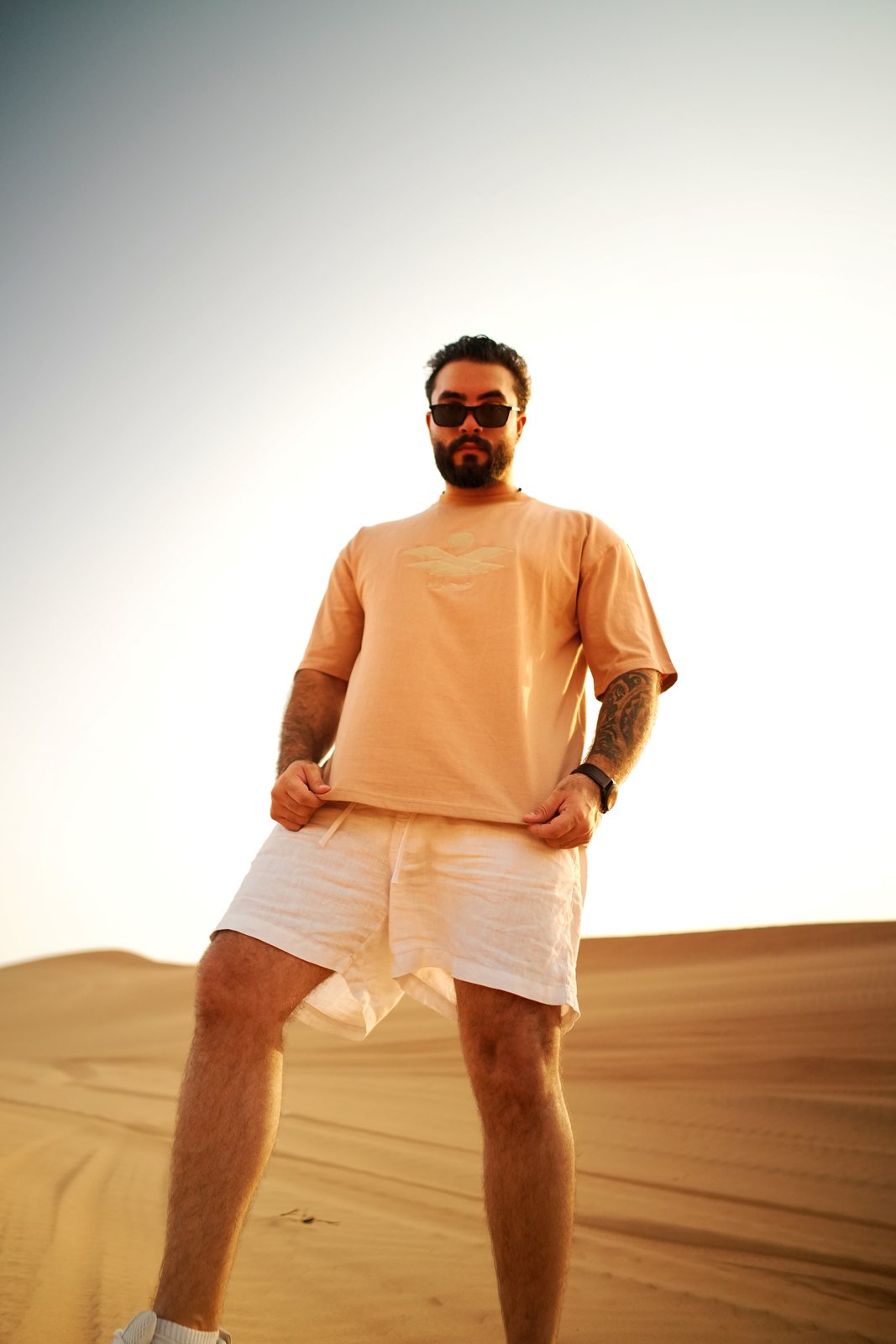 The Empty Quarter tee worn standing on a dune at golden hour