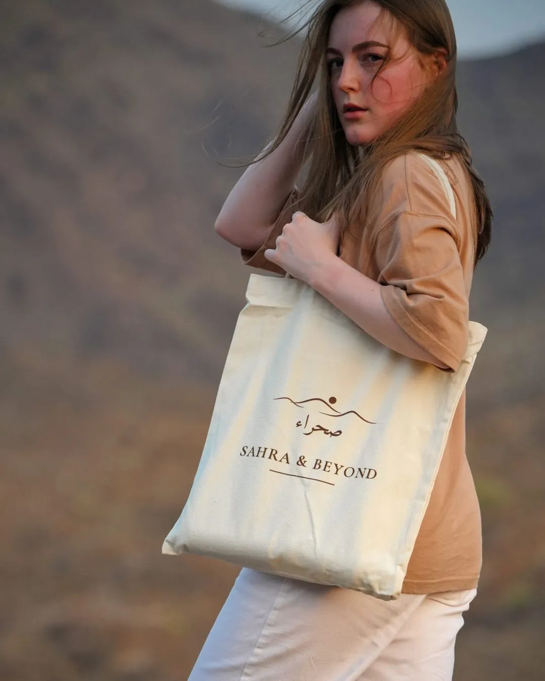 The Sahra Tote in natural canvas, carried over the shoulder