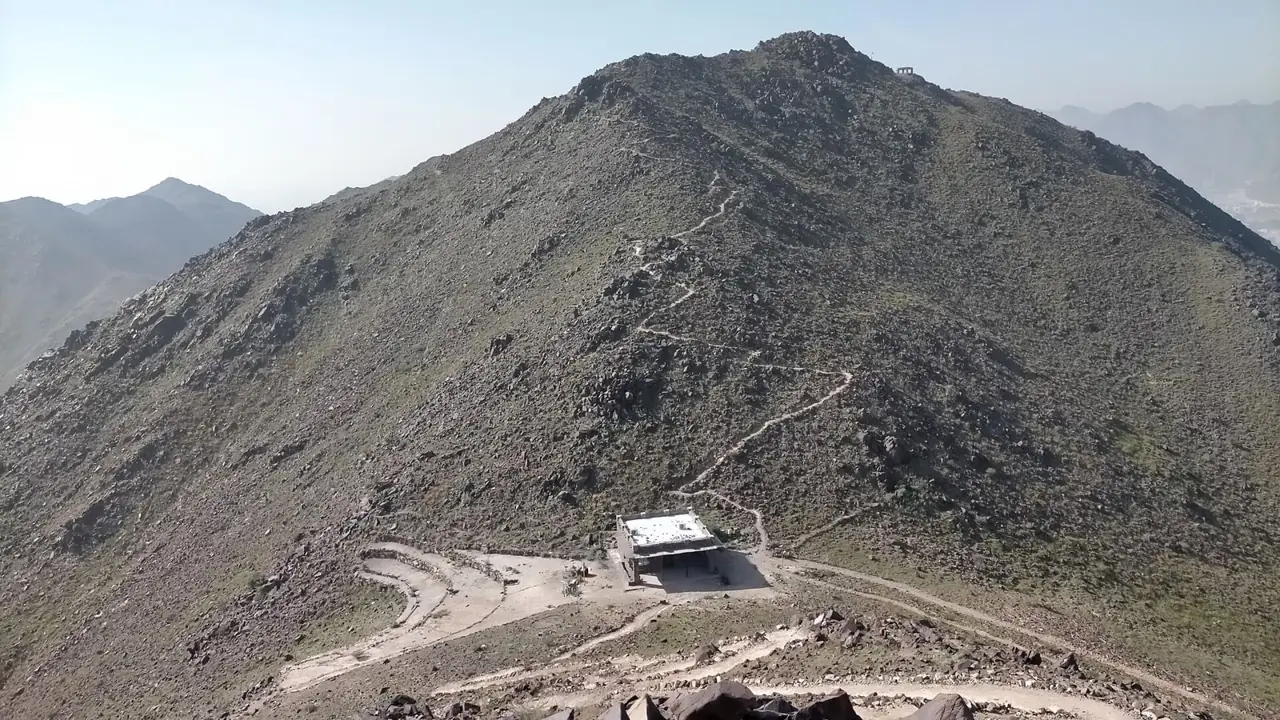 The zigzag path climbing the ridge above Khor Fakkan, with a rest shelter below the summit