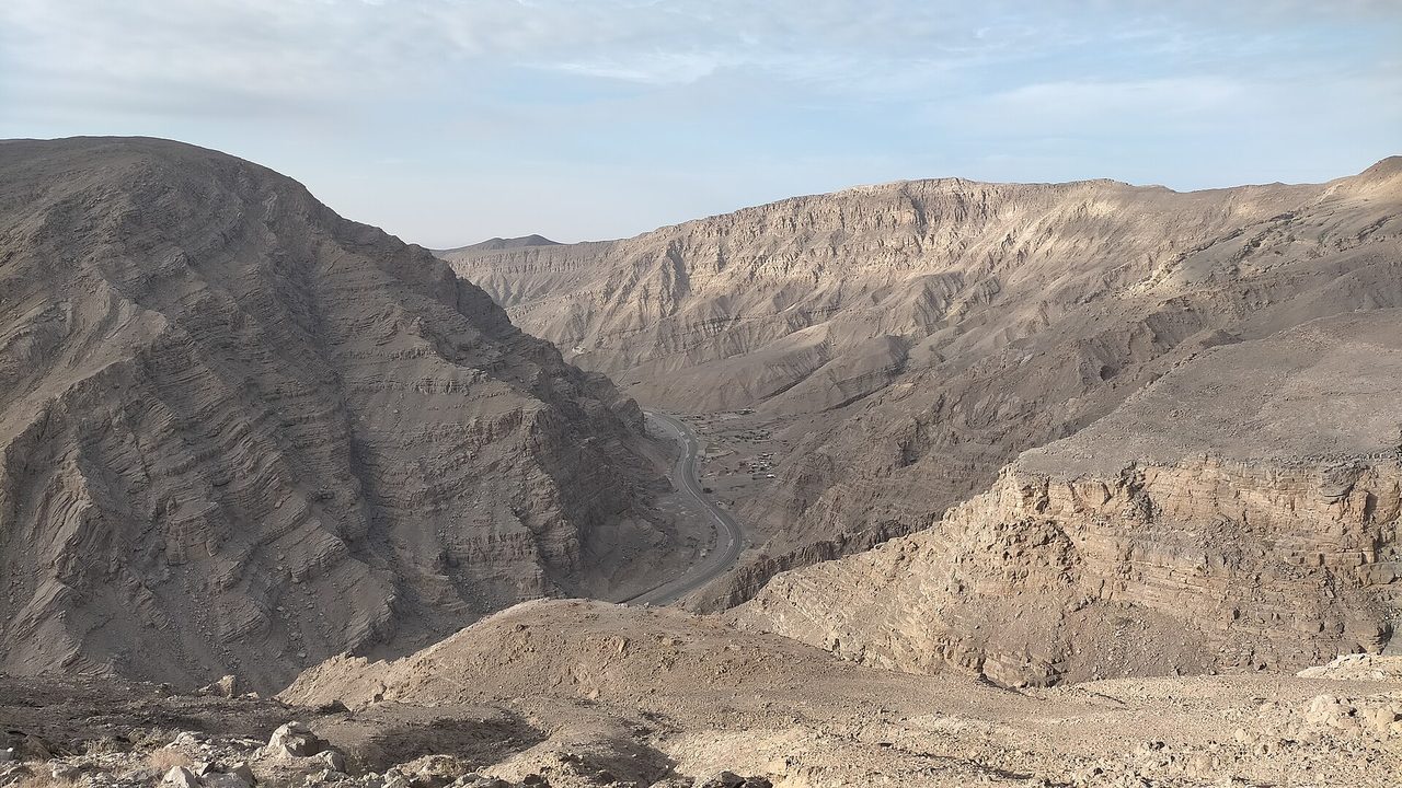 A deep gorge cutting through bare limestone mountains in Wadi Shah, Jebel Jais