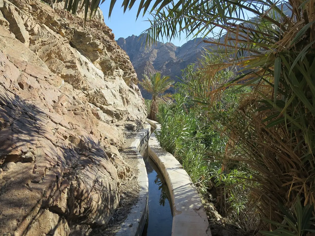 The falaj water channel running along the rock at Wadi Shees