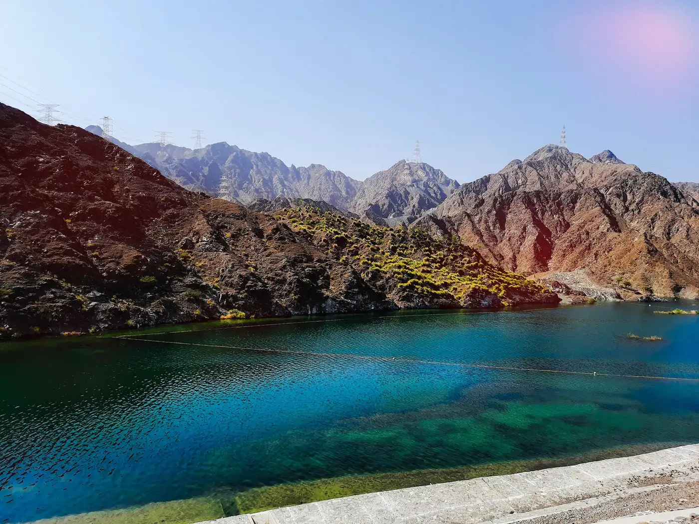 The emerald reservoir of Al Rafisah Dam ringed by the Hajar Mountains near Khor Fakkan, Sharjah.