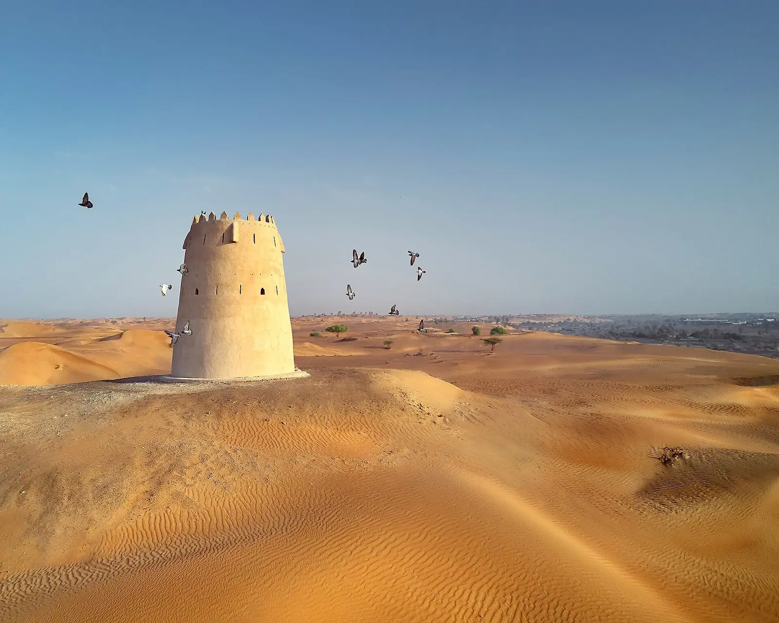 One of the watchtowers of Falaj Al Mualla (the west tower), standing alone in the dunes near the oasis.